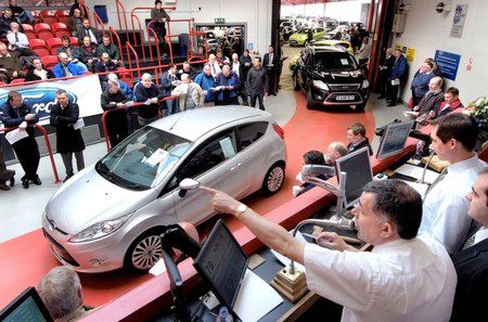 Auctioneer conducting a lively car auction with bidders.